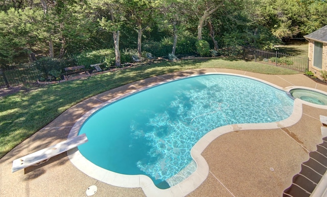 view of swimming pool with a diving board and a lawn