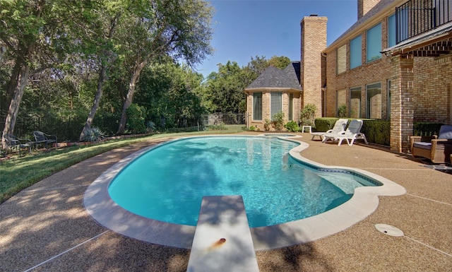 view of pool featuring a patio area and a diving board