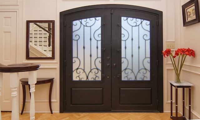 entryway with french doors and light parquet floors