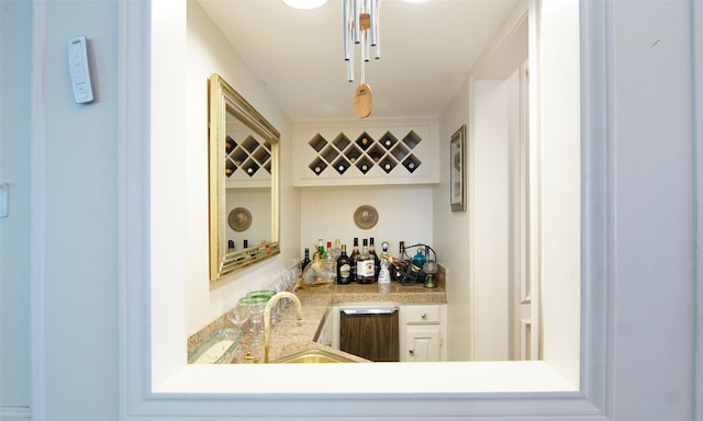 bar featuring sink and white cabinetry