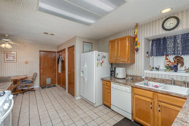 kitchen featuring white appliances, light tile patterned flooring, sink, a textured ceiling, and ceiling fan