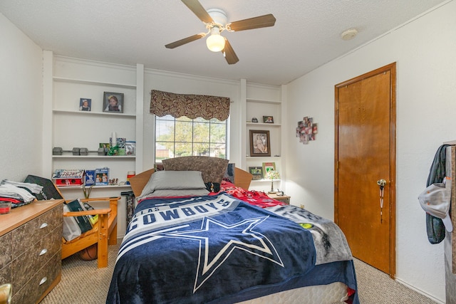 carpeted bedroom featuring a textured ceiling and ceiling fan