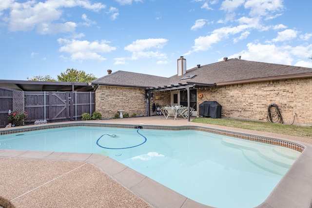 view of swimming pool with a patio and a grill