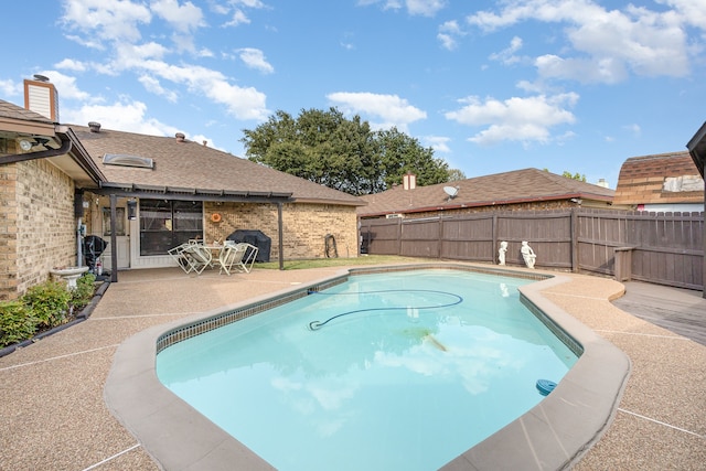 view of pool featuring grilling area and a patio