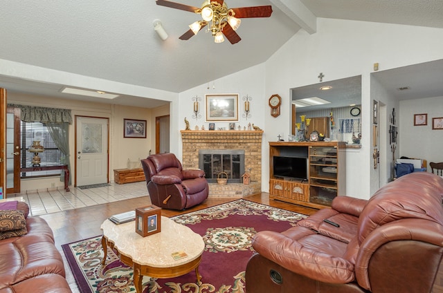 tiled living room featuring a brick fireplace, a textured ceiling, lofted ceiling with beams, and ceiling fan