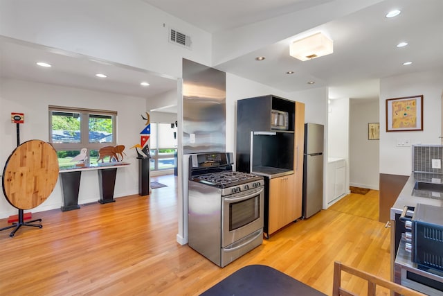 kitchen featuring appliances with stainless steel finishes and light hardwood / wood-style floors