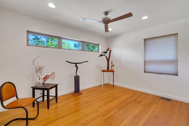 living area with light hardwood / wood-style floors and ceiling fan