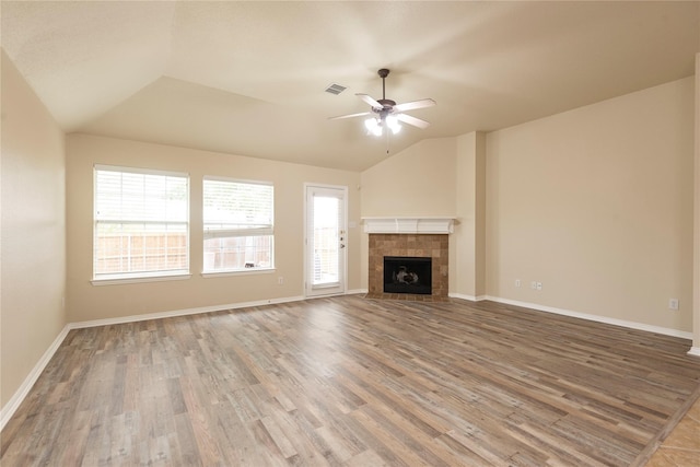 unfurnished living room featuring hardwood / wood-style flooring, a healthy amount of sunlight, lofted ceiling, and ceiling fan