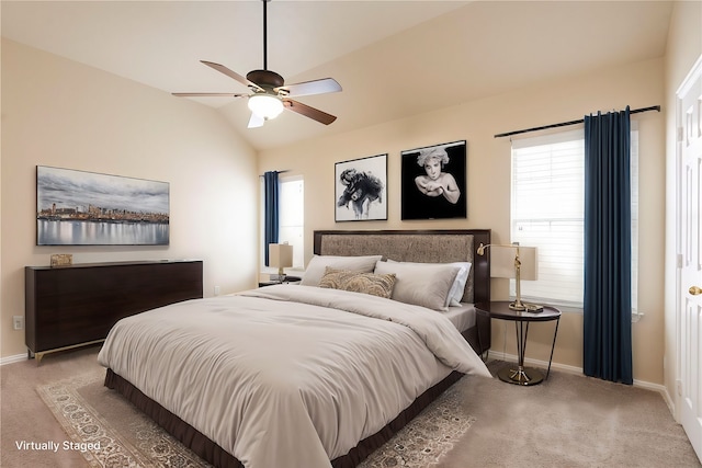 carpeted bedroom with ceiling fan and vaulted ceiling