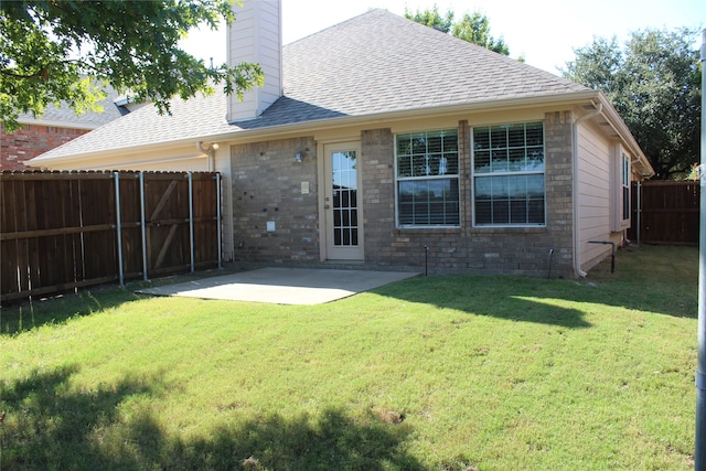 back of property with a yard and a patio area