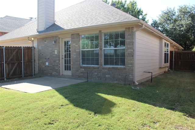 back of property featuring a patio and a lawn