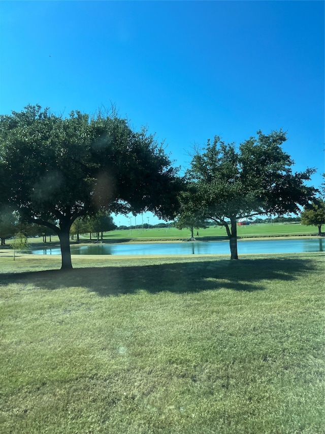 view of property's community with a yard and a water view