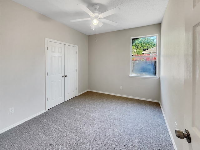 unfurnished bedroom featuring a closet, a textured ceiling, carpet, and ceiling fan