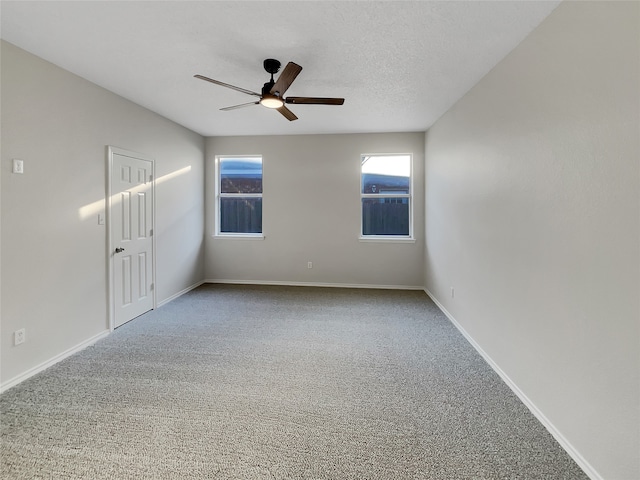 carpeted empty room with a textured ceiling and ceiling fan