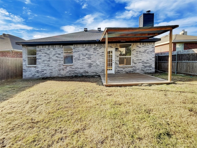 rear view of property featuring a wooden deck and a yard