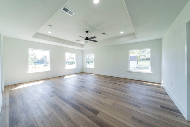 spare room featuring ceiling fan, dark hardwood / wood-style floors, and a raised ceiling