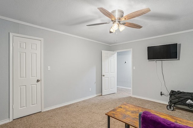 interior space featuring crown molding, carpet floors, a textured ceiling, and ceiling fan