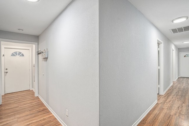 corridor with light hardwood / wood-style floors