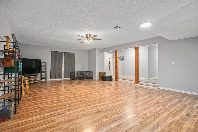 unfurnished living room with light hardwood / wood-style floors, a textured ceiling, and ceiling fan