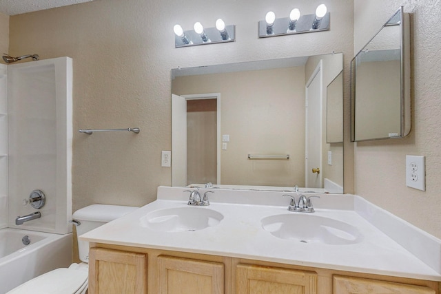 full bathroom featuring  shower combination, vanity, a textured ceiling, and toilet