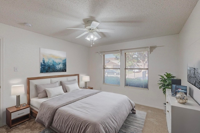 carpeted bedroom with a textured ceiling and ceiling fan