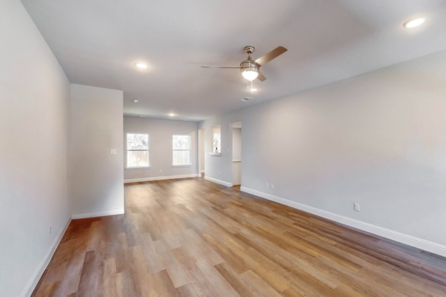 empty room with ceiling fan and light wood-type flooring