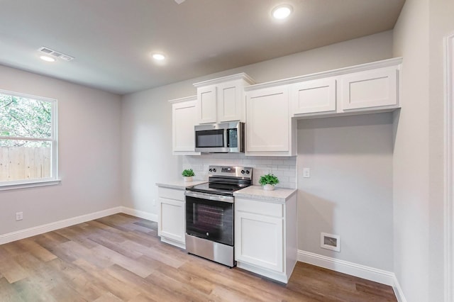 kitchen with white cabinetry, appliances with stainless steel finishes, and light hardwood / wood-style flooring