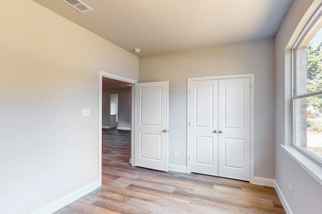 unfurnished bedroom featuring a closet and light hardwood / wood-style floors