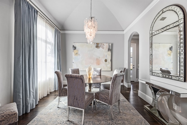 dining space featuring lofted ceiling, ornamental molding, a chandelier, and dark hardwood / wood-style flooring