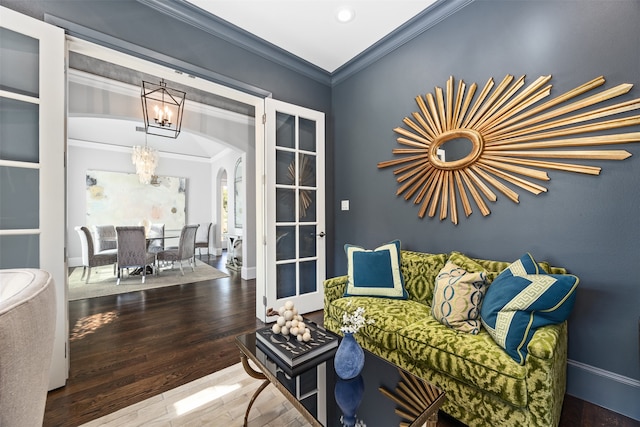 living area featuring crown molding, a notable chandelier, and hardwood / wood-style flooring