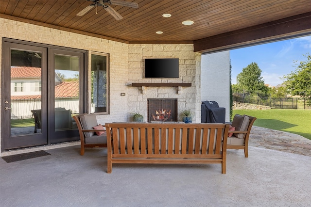 view of patio with ceiling fan and an outdoor stone fireplace