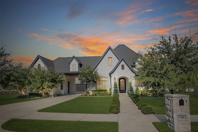 french country home featuring a front yard and driveway