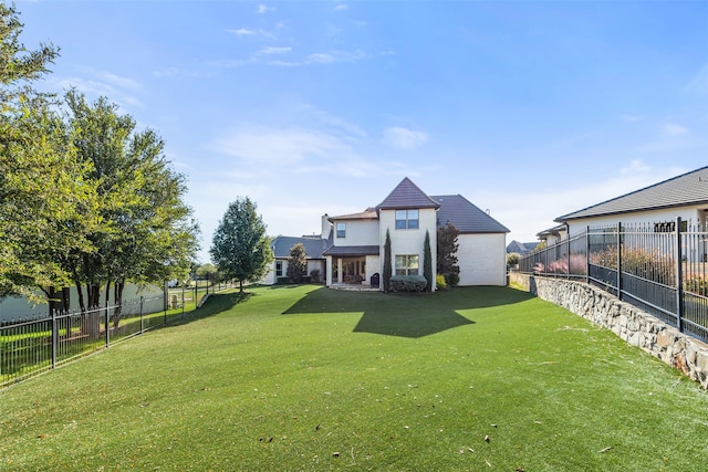 rear view of house featuring a lawn