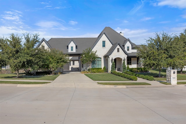 french country inspired facade with a front lawn