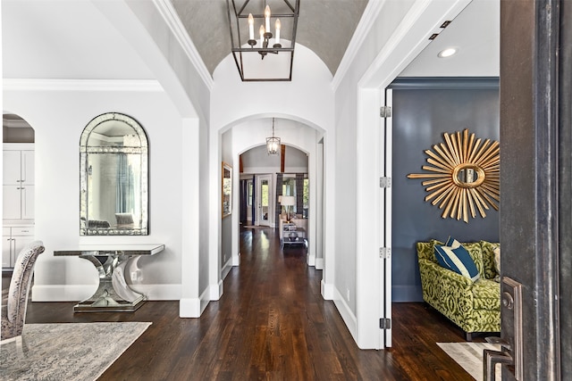 corridor with ornamental molding, dark hardwood / wood-style floors, and a chandelier