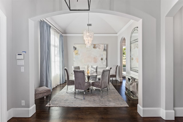 dining area with lofted ceiling, ornamental molding, dark hardwood / wood-style flooring, and a chandelier