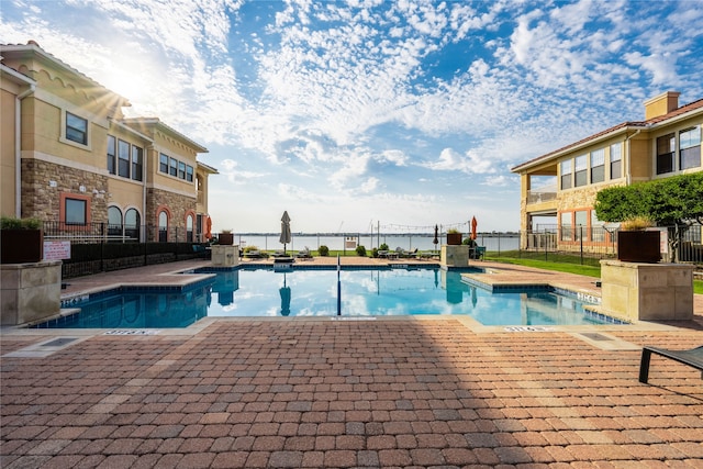 view of swimming pool featuring a patio area and a water view