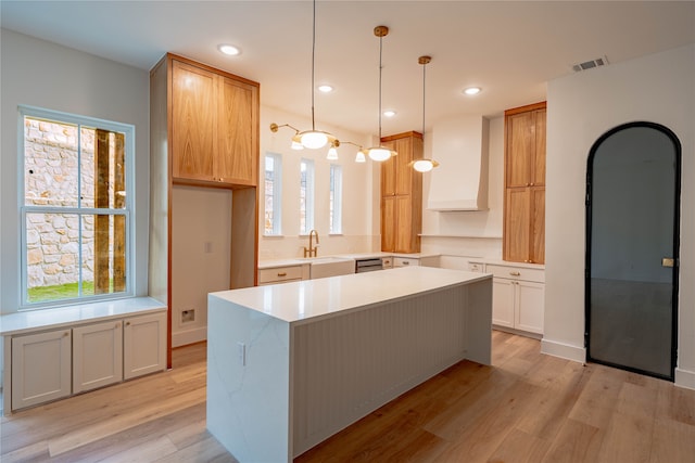 kitchen with pendant lighting, plenty of natural light, and custom exhaust hood