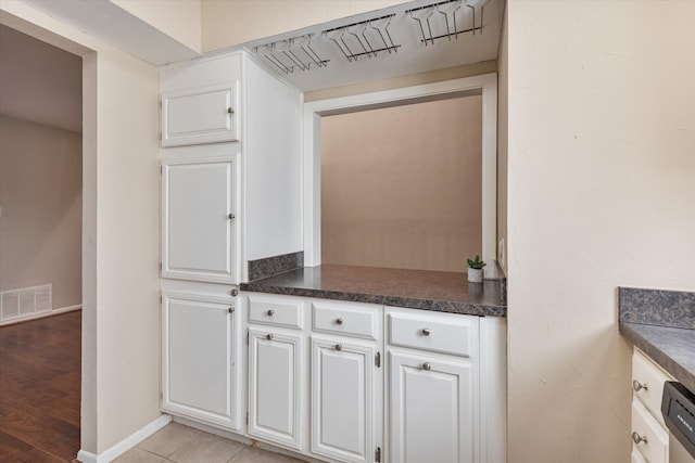 kitchen featuring dishwasher, white cabinetry, and light wood-type flooring