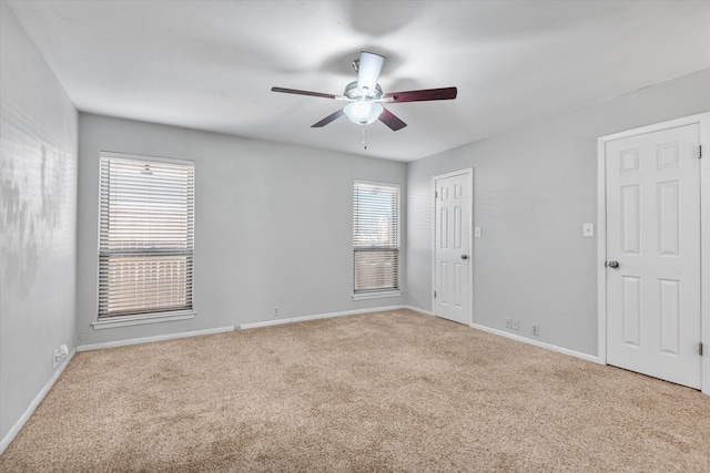 carpeted spare room with ceiling fan