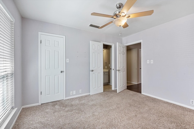 unfurnished bedroom with multiple windows, carpet floors, and ceiling fan