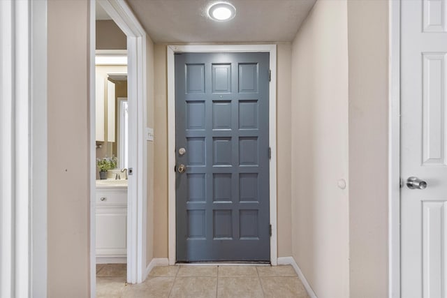 doorway to outside featuring sink and light tile patterned floors