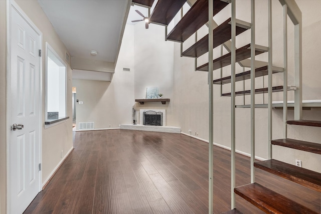 unfurnished living room featuring ceiling fan and dark hardwood / wood-style flooring