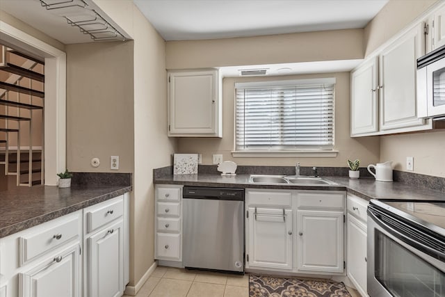 kitchen featuring sink, white cabinetry, stainless steel appliances, and light tile patterned flooring