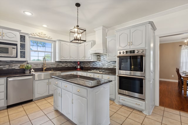 kitchen with custom range hood, appliances with stainless steel finishes, sink, and white cabinets