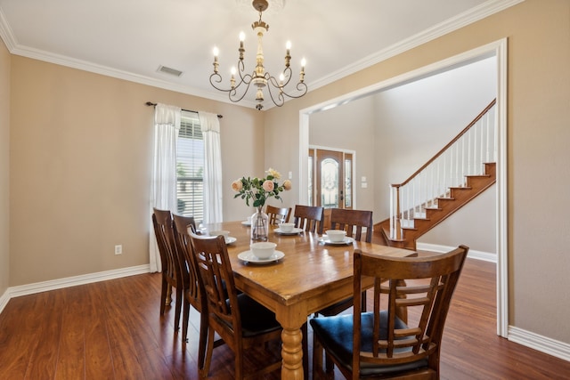 dining room with an inviting chandelier, ornamental molding, and dark wood-type flooring