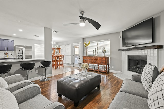 living room featuring dark hardwood / wood-style flooring and ceiling fan with notable chandelier