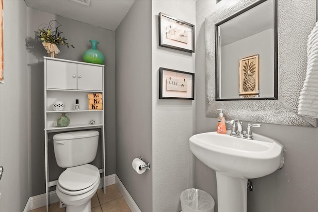 bathroom with toilet and tile patterned floors