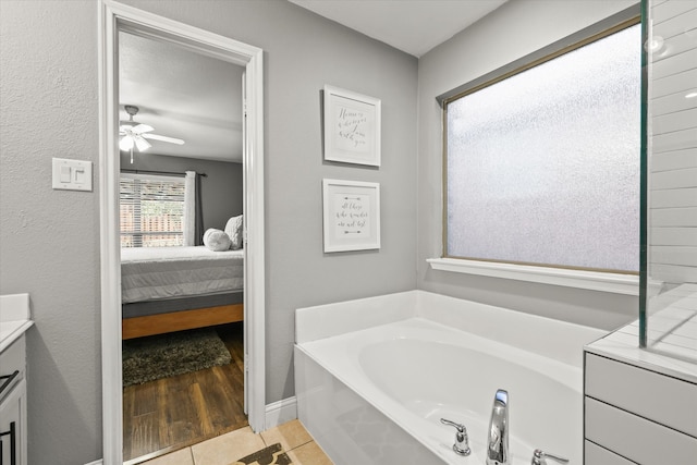 bathroom featuring tile patterned floors, a tub, ceiling fan, and vanity