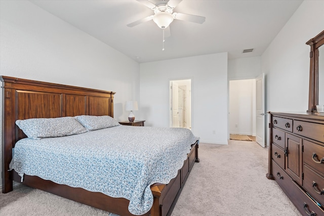 carpeted bedroom with ensuite bathroom and ceiling fan